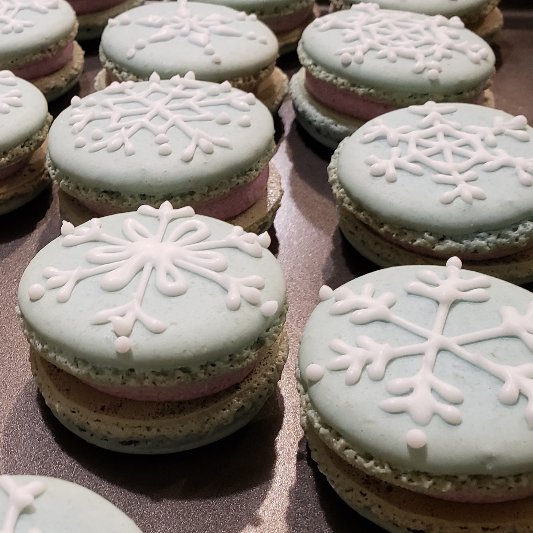 Blue French macarons with snowflake design piped top